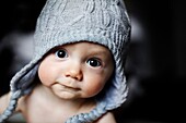 Portrait of a 9 months old baby boy wearing a bonnet
