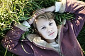 Portrait of a 10 years old girl lying in grass