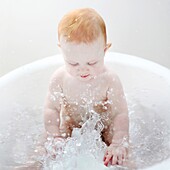 A 9 months baby girl taking a bath