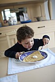 3 years old boy eating a crepe