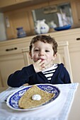 3 years old boy eating a crepe