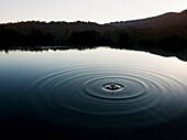 Ripple of water in still lake near mountains