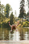 Caucasian boy jumping into lake