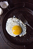 Fried Sunny Side Up Egg in Frying Pan with Fork, High Angle View