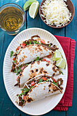 Soft Shell Tacos with Shredded Beef on White Plate, High Angle View