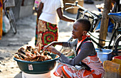 Mädchen verkauft frittierte Fischteile auf dem Markt, Kigamboni, Tansania, Afrika