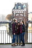 3 Mädchen unterhalten sich draußen in der Specherstadt, Hamburg,  Deutschland, Europa