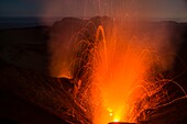Hohe Lava-Eruption des Hauptkraters des aktiven Vulkan Yasur mit Lava Bomben und giftigen Gasen. Kleine Eruption im Nebenkrater des Yasur. Bedeckter, dunkler Himmel zur blauen Stunde. Vanuatu, Insel Tanna, Süd Pazifik