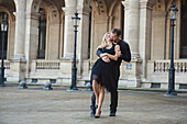Caucasian couple dancing in courtyard