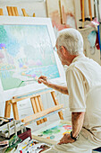 Caucasian artist painting in studio