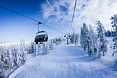 Chair lift gondolas over snowy slopes