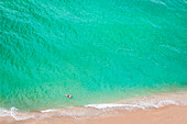 Aerial view of Caucasian man swimming in ocean on beach