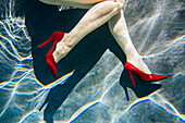 Legs of woman wearing high heels in swimming pool