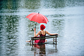 Caucasian woman sitting on bench in flood