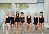 Older Caucasian women wearing black bathing suits at pool