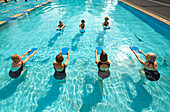 Older Caucasian women taking fitness class in swimming pool