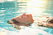 Older Caucasian woman floating in pool