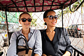 Businesswomen riding in tuk tuk taxi