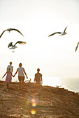 Young family walking along the steep coast, Rota Vicentina, Portugal