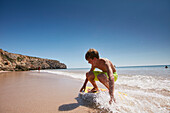 Junger Skimboarder am Strand von Zavial, westliche Algarve, Portugal