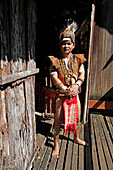 Man in traditional native Iban costume in a longhouse in Borneo, Malaysia, Southeast Asia, Asia