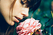 Young Adult Woman Smelling Pink Rose