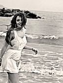 Lächelnde junge erwachsene Frau am Strand