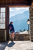 Young Adult Woman Looking at Panoramic View from Village Doorway, Rear View, Lanslevillard, Val Cenis Vanoise, France