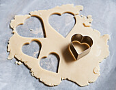 Heart-Shaped Cookie Cutter and Cookie Dough on Wax Paper