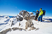 Two men standing on the peak of Cima Groste, ski touring, Brenta Dolomites, Trentino, Italy