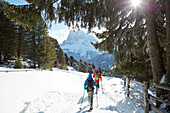 Group of people snow shoeing in front of a mountain hut, Kreuzwiesenalm, Luesen, South Tyrol, Italy