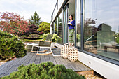 Frau steht an einer Terrassentür mit einer Tasse, coodo moderne Art zu Wohnen, moderne Architektur in Hamburg, Hamburg, Norddeutschland, Deutschland