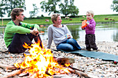 Family sitting around the campfire, Camping along the river Elbe, Family bicycle tour along the river Elbe, adventure, from Torgau to Riesa, Saxony, Germany, Europe