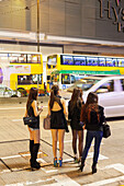 Four young Chinese women on the street, traffic, sexy, shopping area Causeway Bay, handbags, evening, Hong Kong, China, Asia
