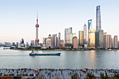 Dusk on the Bund, visitors, skyline of Shanghai, Oriental Pearl Tower, Jinmao Tower, Shanghai World Financial Center, Shanghai Tower, illuminated boat on Huangpu River, Shanghai, China, Asia