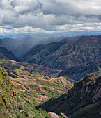 The colourful mountainous landscape of Toro Toro National Park, with a rainstorm in the distance, Bolivia