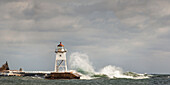 Large waves splashing up to a lighthouse, Grand Marais, Minnesota, United States of America