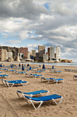 Blue lounge chairs on the beach along the mediterranean, Benidorm, Spain