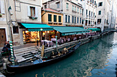Gondola In A Canal By A Restaurant, Venice, Italy
