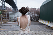 Woman in low-back dress walking in industrial area