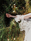 Bride wearing wedding dress in tall grass