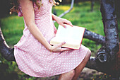 Close up of woman reading book in tree