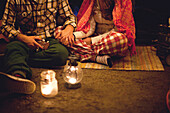 Couple relaxing in camping tent at night