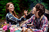 Couple feeding each other in forest