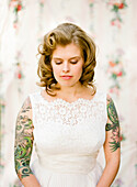 Close up of bride with tattoos wearing wedding dress