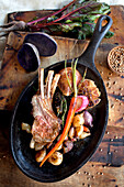 Pan of roasted rack of ribs and vegetables