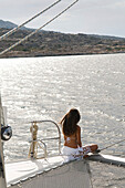 Woman admiring ocean view from sailboat deck