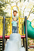 Caucasian father and son playing on play structure
