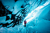 Hiker walking in ice cave