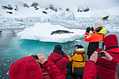 Passagiere von Expeditions-Kreuzfahrtschiff MS Hanseatic Hapag-Lloyd Kreuzfahrten blicken von Zodiac Schlauchboot auf Seeleopard Hydrurga leptonyx auf Eissscholle, Paradise Bay Paradise Harbor, Danco-Kueste, Grahamland, Antarktis